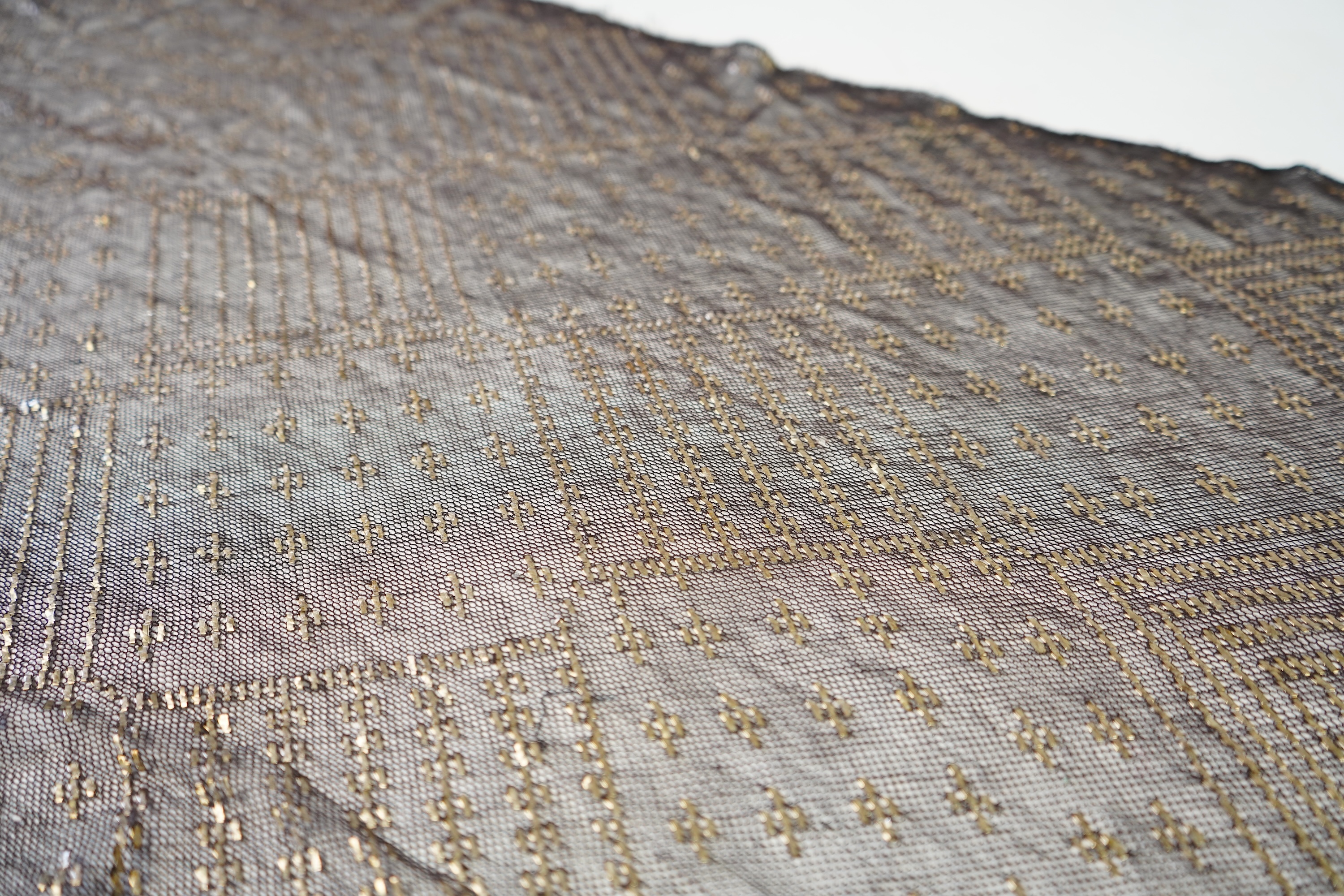 A 1930’s Egyptian decorative metal on black net evening stole. Approximately 218cm long. Condition - the rolled edges are frayed but the colour and design are intact.